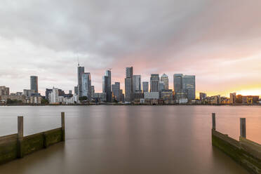 Modern skyline by Thames River in city against cloudy sky during sunset, London, UK - WPEF03413