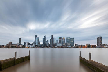 Modern skyline by Thames River in city against cloudy sky at dusk, London, UK - WPEF03414