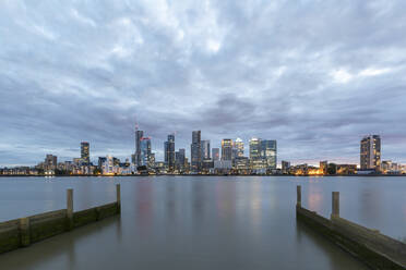 Modern skyline with skyscrapers by Thames River in city against cloudy sky at dusk, London, UK - WPEF03415