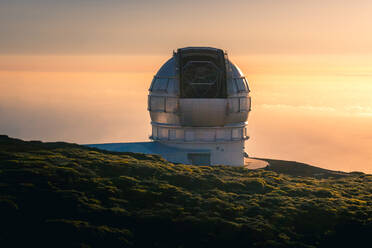 Atemberaubende Landschaft mit Sternwarte auf einem Hügel über den Wolken bei Sonnenuntergang - ADSF15901