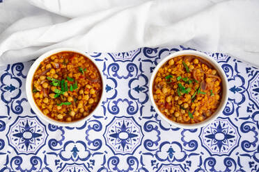 Two bowls of vegan stew with chick-peas, red lentils, tomatoes, Spanish onions and mint - LVF09025