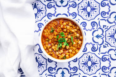 Bowl of vegan stew with chick-peas, red lentils, tomatoes, Spanish onions and mint - LVF09026