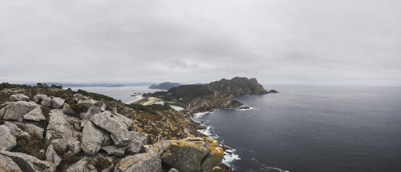 Blick auf die Cíes-Inseln auf dem Meer gegen den bewölkten Himmel, Vigo, Provinz Pontevedra, Galicien, Spanien - RSGF00288