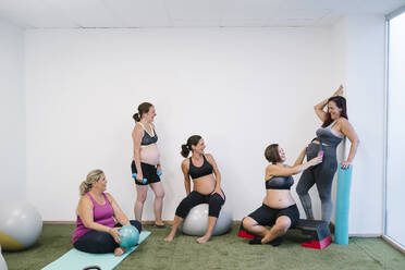 Gruppe schwangerer Frauen bei Übungen im Yogastudio - MPPF01112