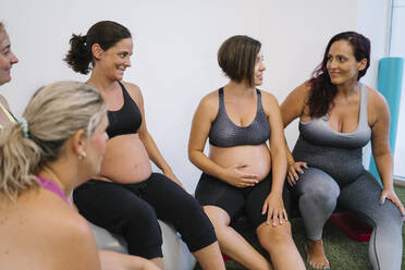 Group of pregnant females talking with each other at yoga studio - MPPF01114