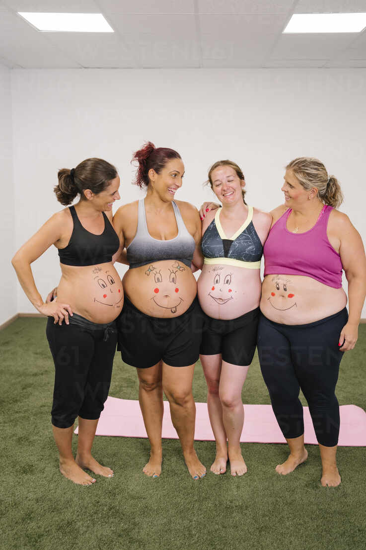 Pregnant Mothers Smiling At Their Their Baby Bumps In A Studio, Baby Not  Smiling At Months