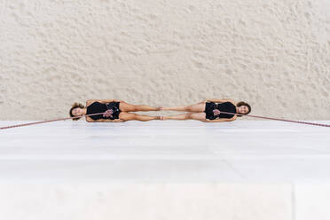 Aerial dancers hanging against wall - DLTSF01261