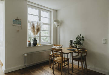 Modernes Interieur eines Zimmers mit Tisch und Stühlen am Fenster in einem alten Haus - MFF06195