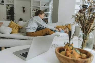 Frau und Junge spielen auf dem Sofa zu Hause - MFF06207