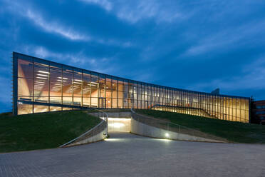 Moderne Universitätsgebäude, nachts beleuchtete Glasfassade, auf einer geschwungenen Grundfläche - MINF15175