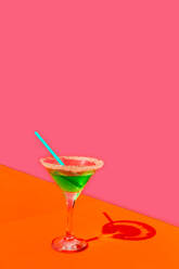 Grünes Getränk mit Strohhalm vor rosa Hintergrund - ERRF04534