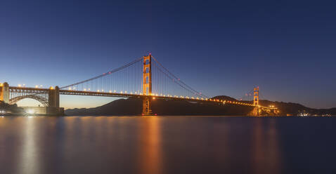 Illuminated Golden Gate Bridge over sea against clear sky at San Francisco, California, USA - AHF00120