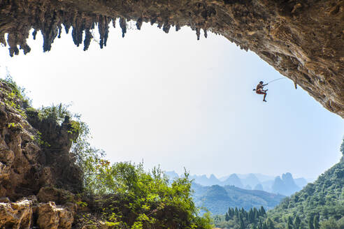 Mann beim Klettern in Odin's Den in Yangshuo, einem Klettermekka in China - CAVF89765