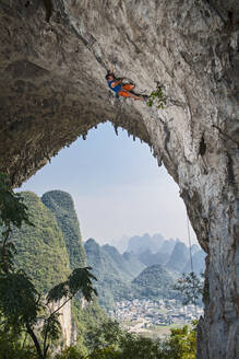 Mann beim Klettern auf dem Mondberg in Yangshuo, einem Klettermekka in China - CAVF89766