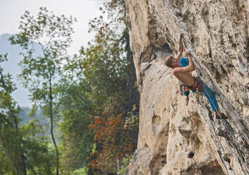 Man climbing on the limestone cliff 