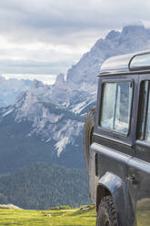 Geländewagen gegen Berggipfel von Sexten, Dolomiten, Südtirol, Italien aus gesehen - MMAF01404