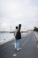 Junger Mann mit Gitarre auf der Promenade - DCRF00889