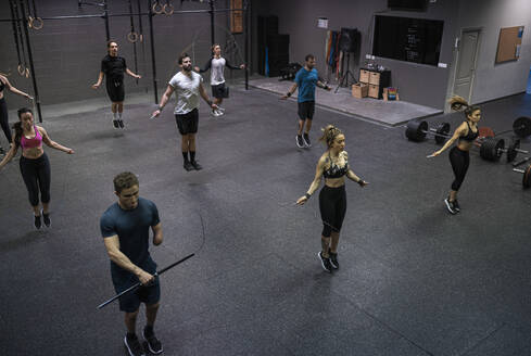 Group of people training with jumping rope in gym - SNF00564