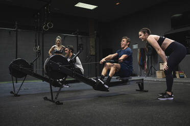 Athletes exercising with rowing machine at gym - SNF00566