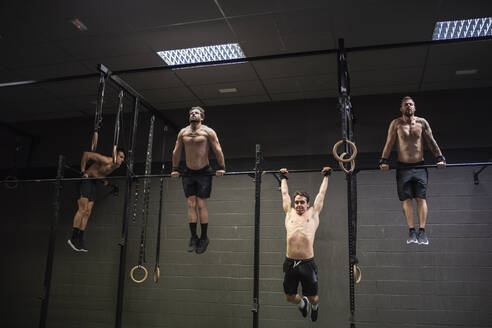 Athletes doing pull ups exercise on rod at gym - SNF00575