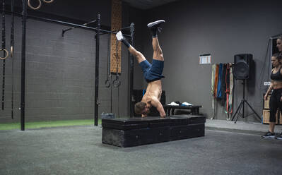 Behindertensportler macht Handstand beim Training im Fitnessstudio - SNF00577