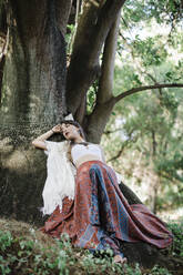 Young woman resting under tree at park - DCRF00910