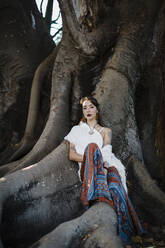 Woman resting while sitting under tree - DCRF00920