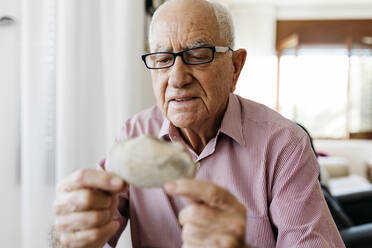 Retired senior male looking at fossil - JRFF04777