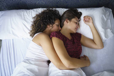 Lesbian couple sleeping on bed at home - JSMF01793