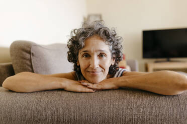 Reife Frau ruht sich auf dem Sofa zu Hause aus - TCEF01195