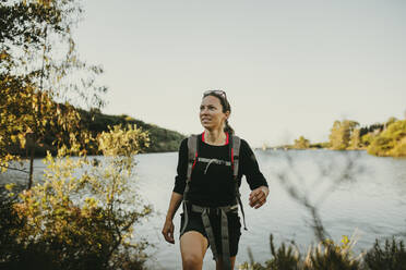 Frau, die gegen den Fluss am Berg Sierra Morena in der Sierra De Hornachuelos, Cordoba, Spanien, läuft - DMGF00154