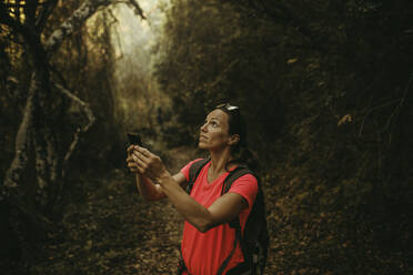 Frau mit Mobiltelefon in der Hand in der Sierra De Hornachuelos, Cordoba, Spanien - DMGF00177