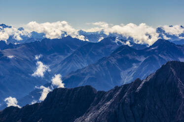 Österreich, Tirol, Blick auf Wolken, die über den Gipfeln des Wettersteingebirges schweben - THAF02900
