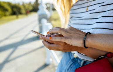 Freundinnen benutzen Mobiltelefon auf dem Gehweg - MGOF04501