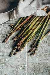 Raw Organic Asparagus Spears, on rustic surface - ADSF16217