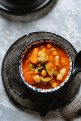 Veganes Essen, Kichererbsen gedünstet mit Tomaten, Zucchini, Karotten und Paprika auf Schale - ADSF16222