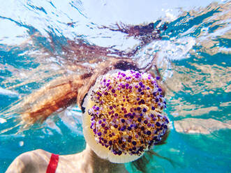 Unbekannte junge Frau mit Tauchermaske schwimmt in tiefem, transparentem Meerwasser und erforscht Quallen - ADSF16353