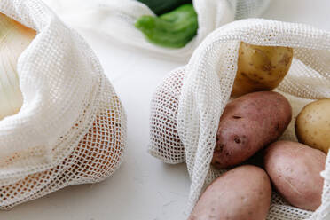 Nahaufnahme von rohen Kartoffeln in umweltfreundlichen Stoffbeuteln auf dem Tisch in der Küche - ADSF16407