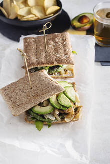 Draufsicht auf ein frisch zubereitetes Sandwich mit Gemüseschnitzel, das zum Mittagessen auf dem Tisch im Café liegt - ADSF16413