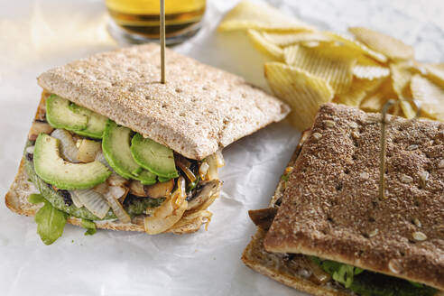 Nahaufnahme eines frisch zubereiteten Sandwichs mit Gemüseschnitzel auf einem Tisch im Café zum Mittagessen - ADSF16414