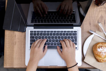 Female entrepreneur using laptop at table in cafe - EGAF00912