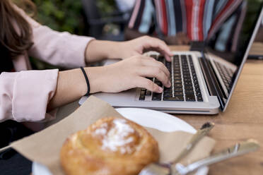 Geschäftsfrau arbeitet am Laptop am Tisch im Café - EGAF00913