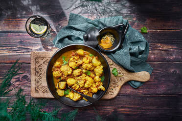 Top view of delicious cauliflower stew with turmeric and vegetables served on wooden table for dinner - ADSF16529