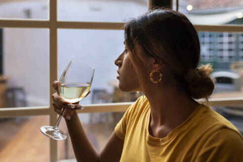 Schöne lateinische Frau trinkt Weißwein an der Bar - JPTF00590