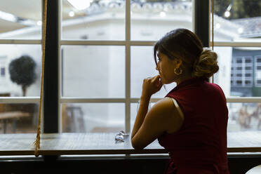 Junge Frau sitzt an der Bar und wartet - JPTF00592