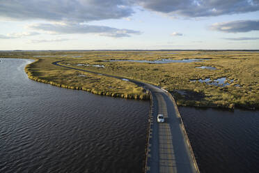 USA, Maryland, Drohnenansicht einer Straße, die sich über Sümpfe entlang des Blackwater River an der Ostküste erstreckt - BCDF00447