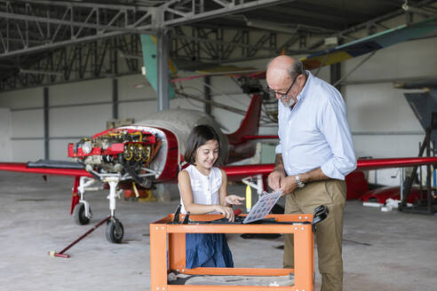 Enkelin und Großvater wählen Werkzeuge zur Reparatur von Flugzeugen aus - EIF00190