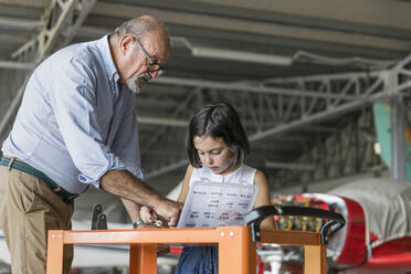 Enkel und Großvater wählen Werkzeuge zur Reparatur von Flugzeugen aus - EIF00192