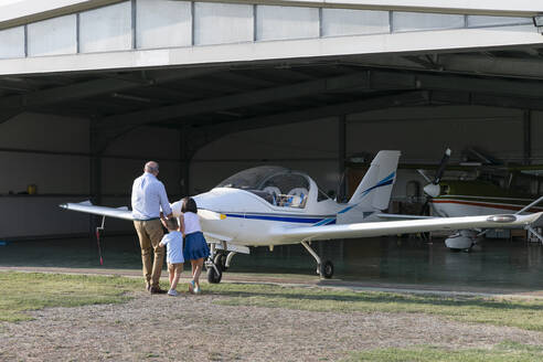 Kinder und Großvater beim Ziehen eines Flugzeugs - EIF00201