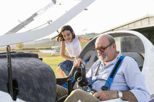 Junges Mädchen im Cockpit eines Flugzeugs mit Großvater auf dem Flugplatz - EIF00209